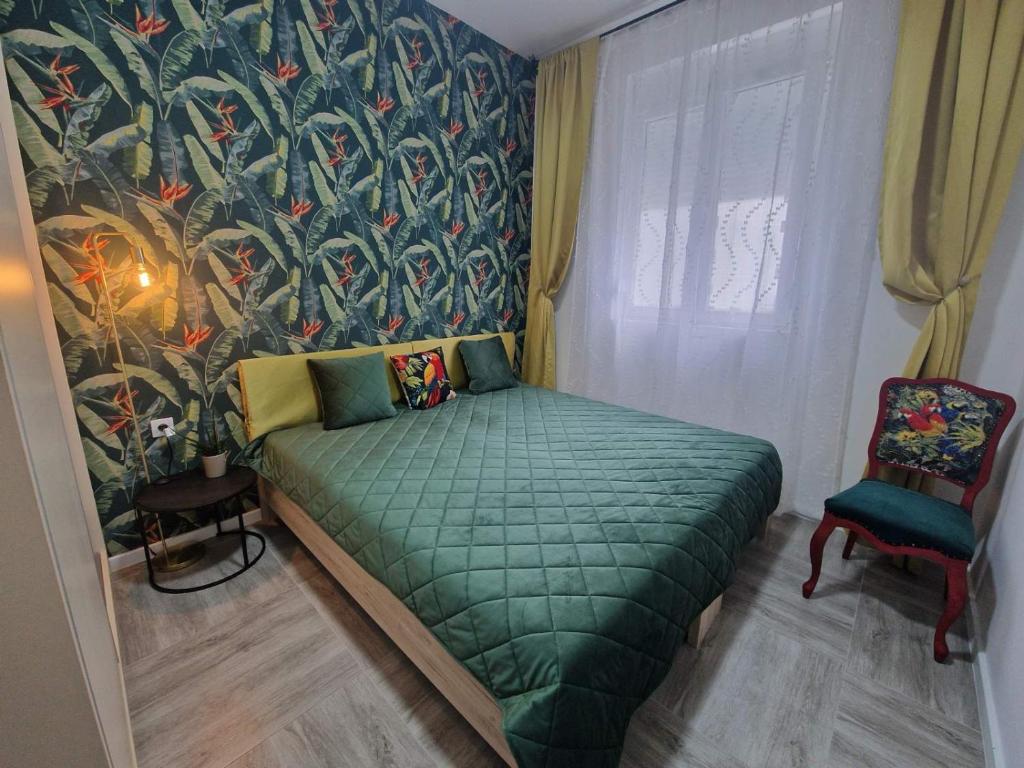 Un dormitorio con una cama verde y una silla. en Parrot Chic Apartment, en Bar