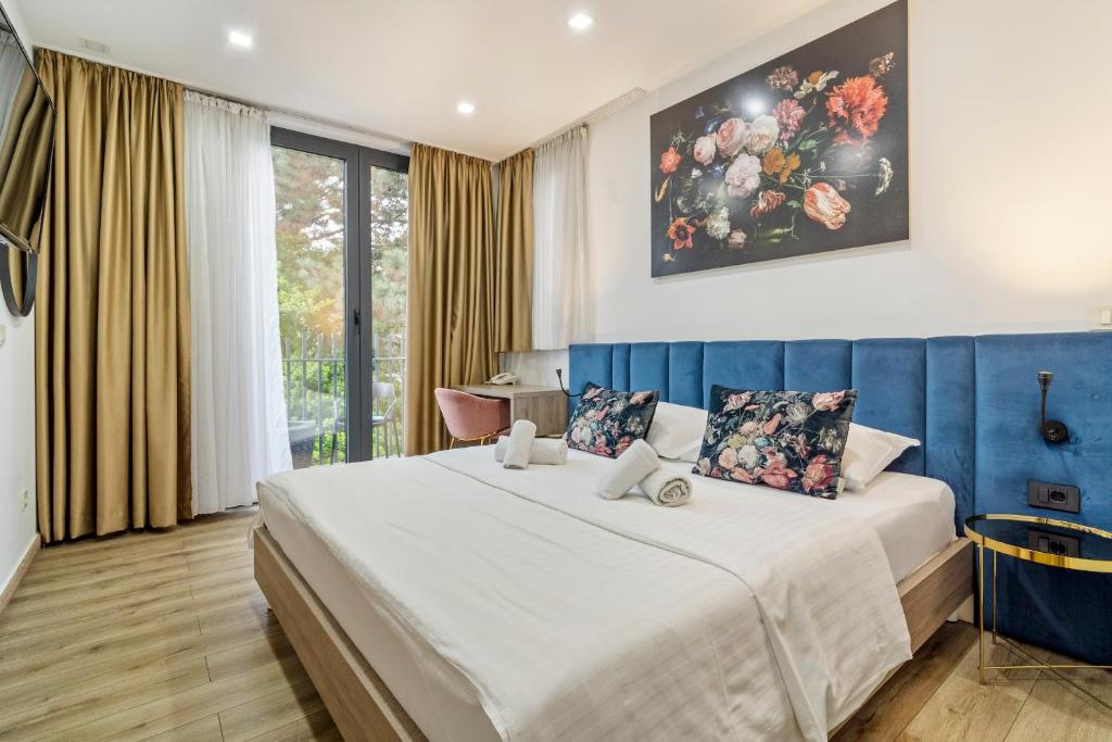 sypialnia z dużym łóżkiem i niebieską ścianą w obiekcie Hotel National w Zagrzebiu