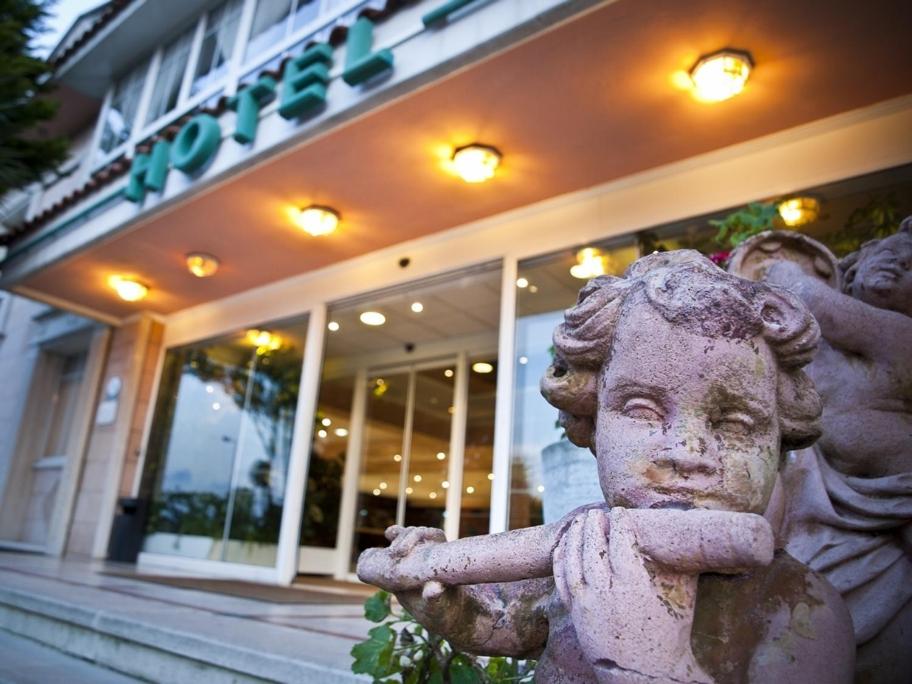 a statue of a child in front of a building at Hotel Begoña Park in Gijón