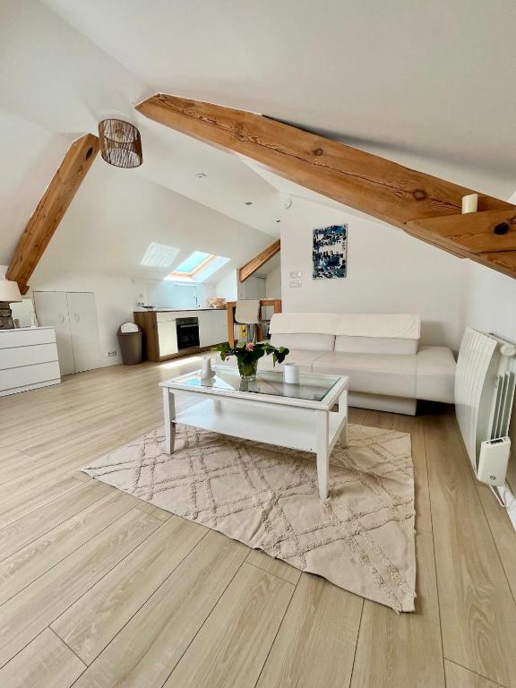 un salon avec un canapé blanc et une table dans l'établissement Appartement atypique proche colmar, à Horbourg-Wihr