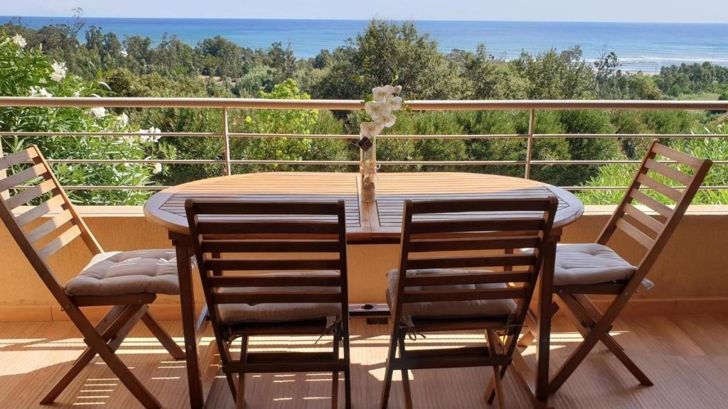 a table and chairs on a balcony with a view of the ocean at SOLENZARA sea view in Sari Solenzara