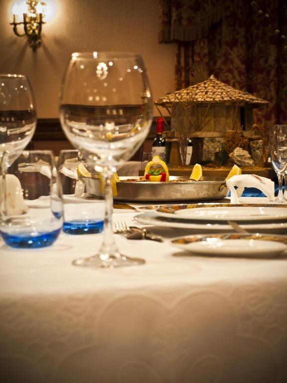 a table with wine glasses on a white table cloth at Hotel Begoña Park in Gijón
