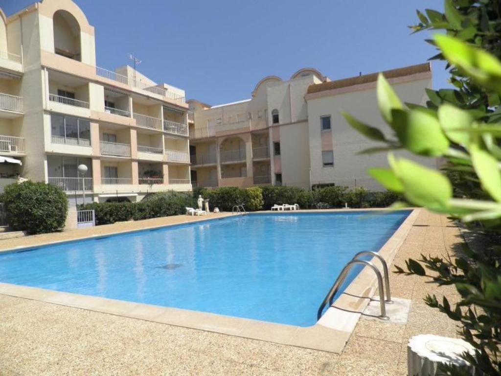 une grande piscine devant un immeuble dans l'établissement Gruissan Plage Studio RDC avec Piscine Wifi Parking Clim, à Gruissan