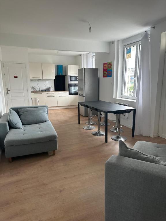 un salon avec une table et un canapé dans l'établissement Sweet mother share studio, à Lille