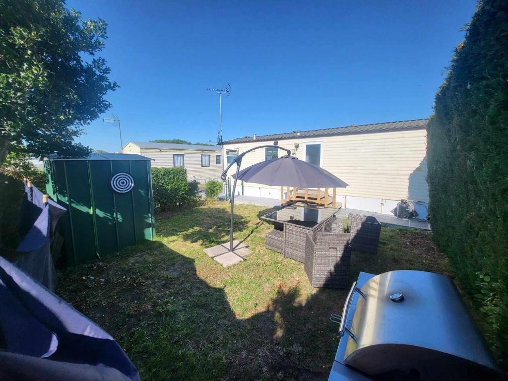 a backyard with a picnic table and an umbrella at Living Holiday in Middelkerke