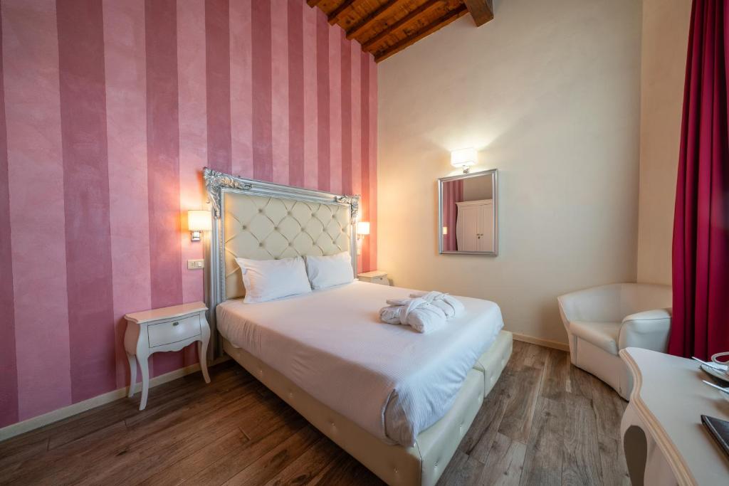 a bedroom with a white bed and pink walls at Residenza Conte di Cavour & Rooftop in Florence