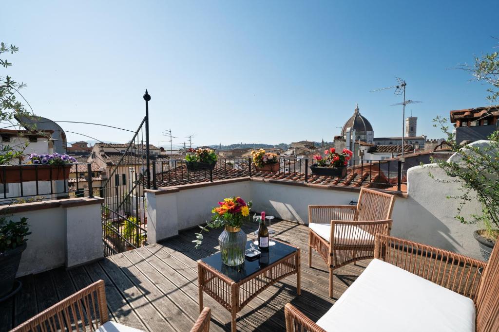 a patio with tables and chairs on a balcony at Residenza Conte di Cavour & Rooftop in Florence