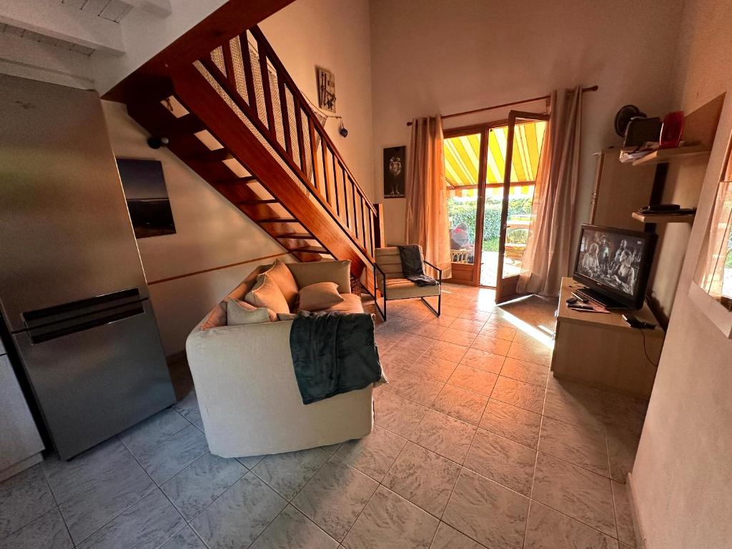 un salon avec un canapé et un escalier dans l'établissement Les Oiseaux de Porticcio, à Grosseto-Prugna