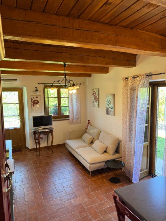 salon z kanapą i telewizorem w obiekcie Agriturismo La Valle Dimenticata w mieście Urbania