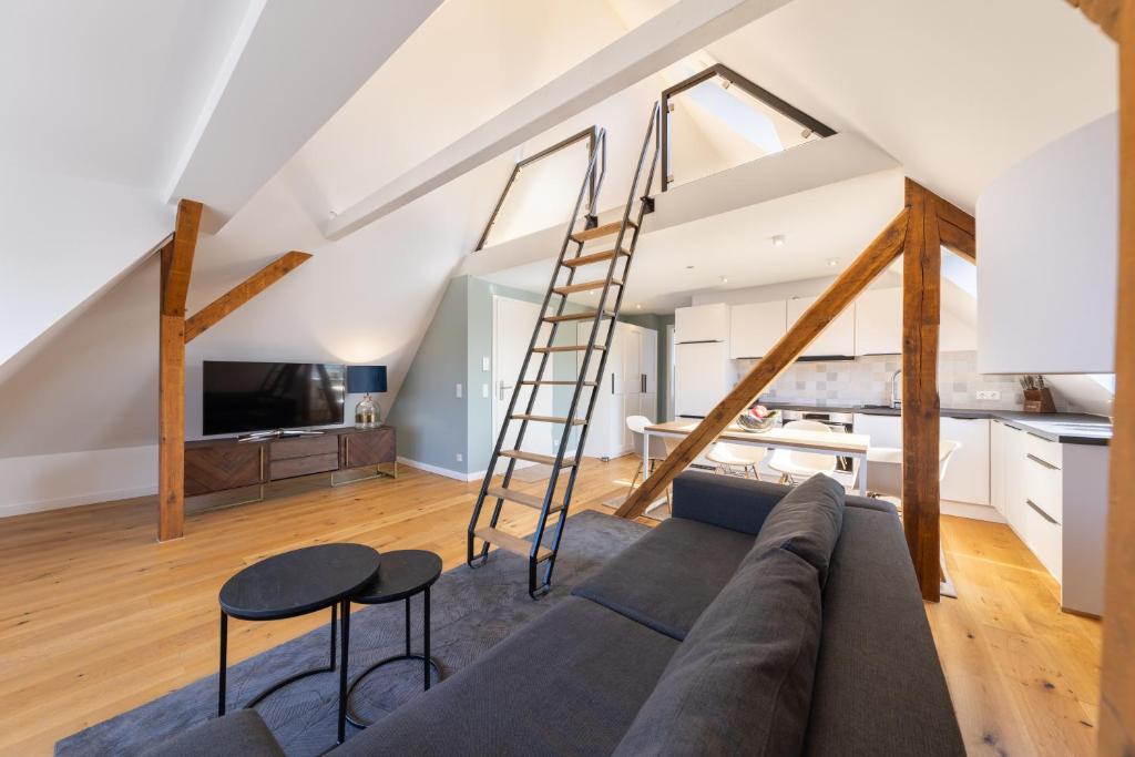 Ferienwohnung Strom ahoi - premium - modern - inkl Stellplatz - 200m zum Alten Strom - Wasserblick في فارنمونده: غرفة معيشة مع أريكة وسلم