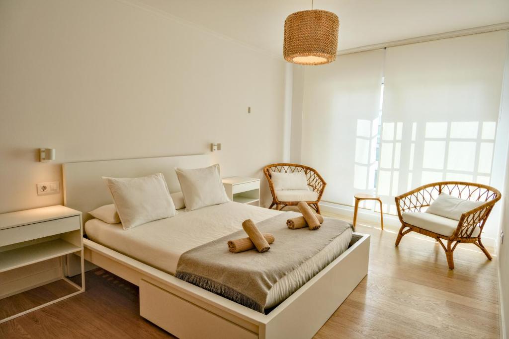 a bedroom with a bed and two chairs at Piano 8 Sanxenxo in Sanxenxo