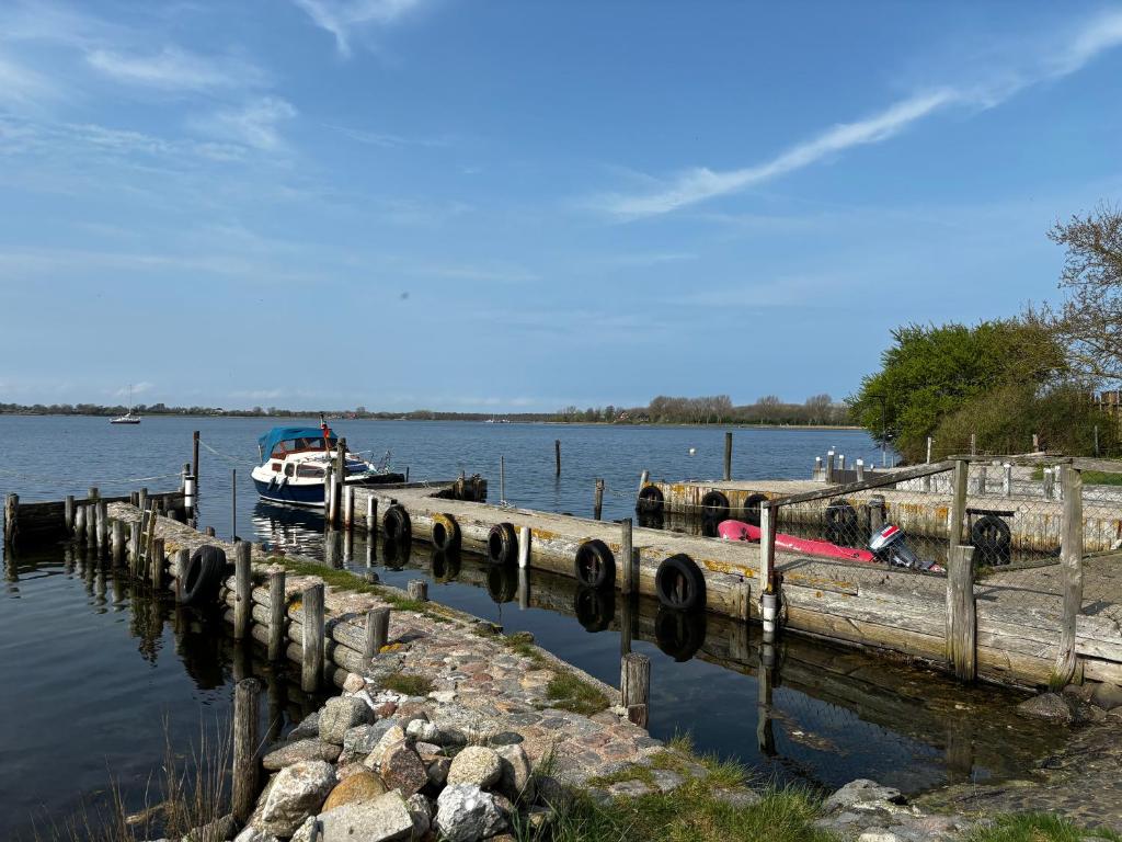 a boat is docked at a dock on the water at Ferienwohnung 2 mit eigenem Bootsanleger in Maasholm