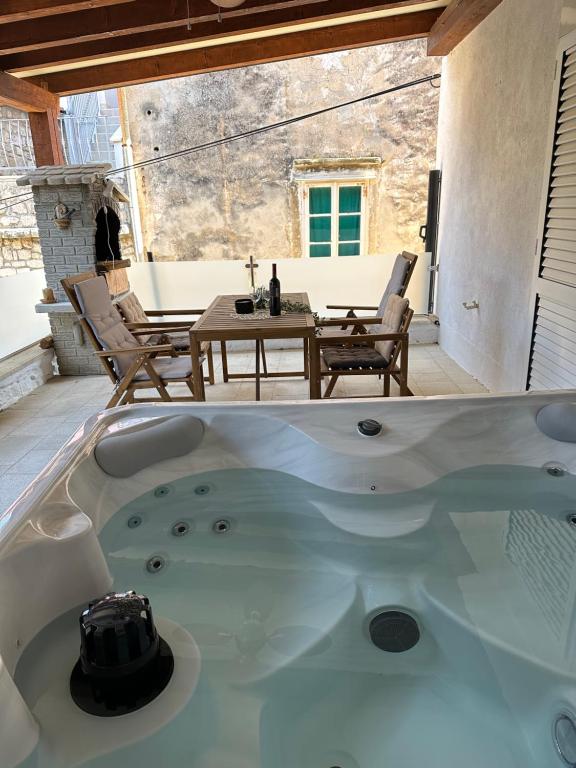 a bath tub on a patio with a table and chairs at Luxury Old Town Rab Studio Apartments in Rab