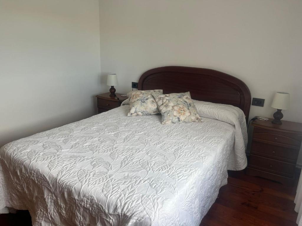 a bedroom with a white bed with two night stands at Casa Vista Alegre en Oia in Oia