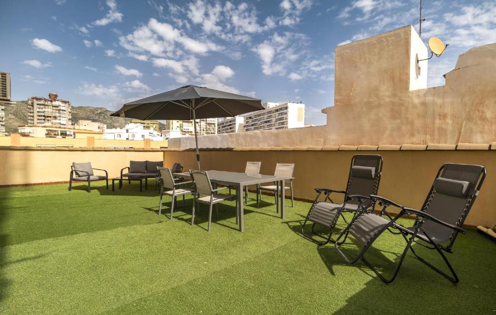 a table and chairs with an umbrella on a roof at Stunning Apartment In Torremolinos in Torremolinos