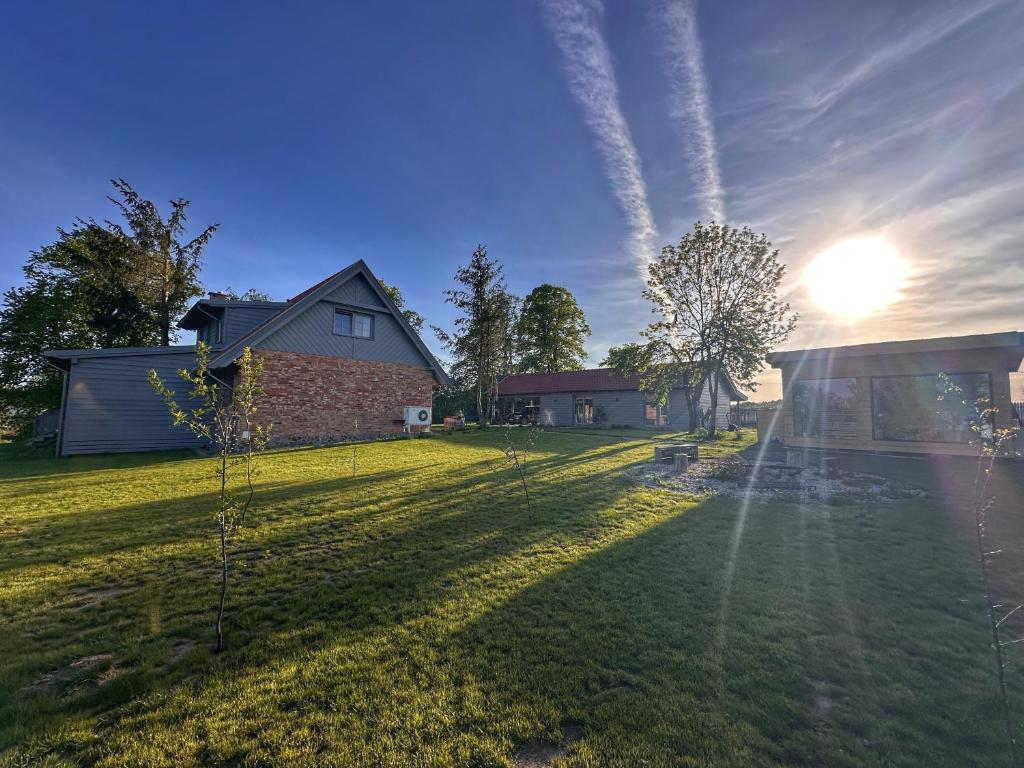 a yard with a house and the sun in the sky at Dla Pary - Sauna, Joga, Masaż, Jezioro in Mikołajki