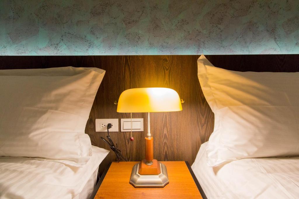 a lamp sitting on a table between two beds at Book 5 in Dongshan