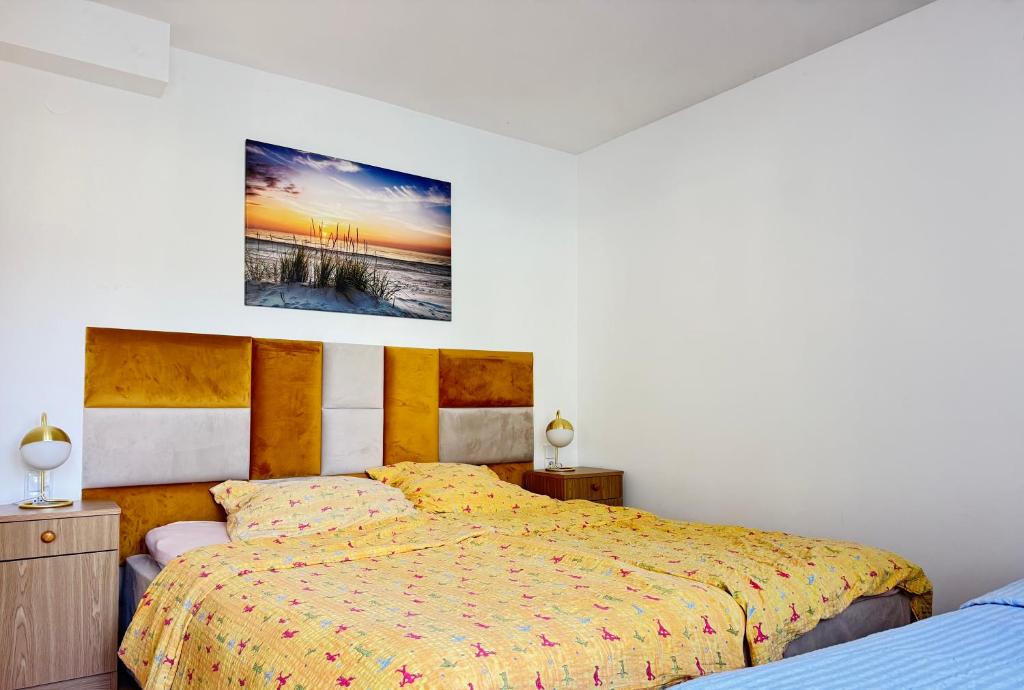 a bedroom with two beds and a painting on the wall at Pokoje u Alicji in Władysławowo