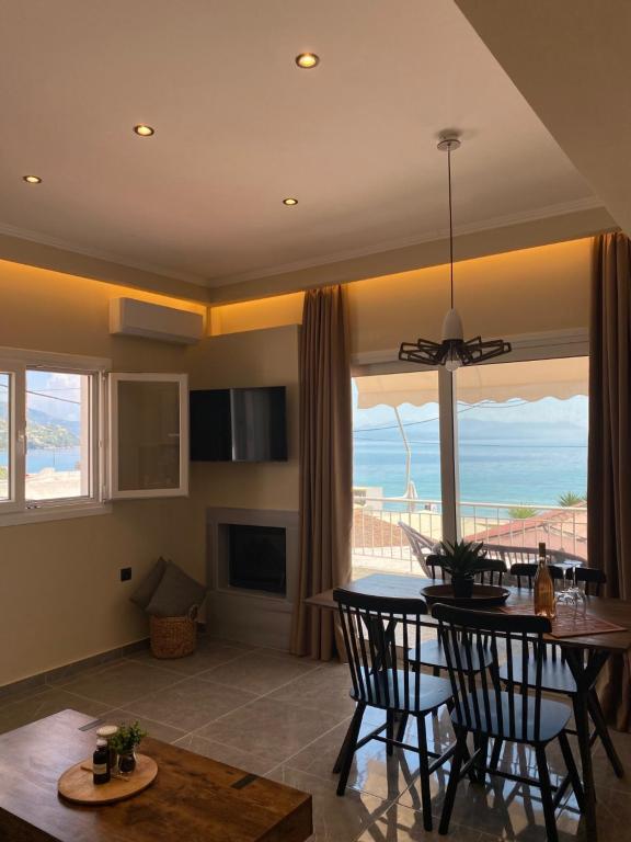 a living room with a table and chairs and a view of the ocean at Phebiata in Ýpsos