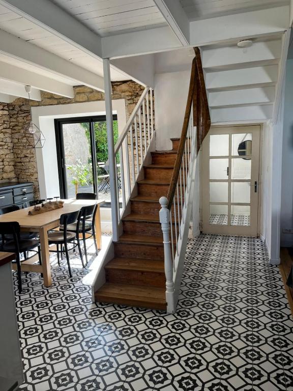 un couloir avec un escalier, une table et des chaises dans l'établissement La maison du port, à Ploudalmézeau