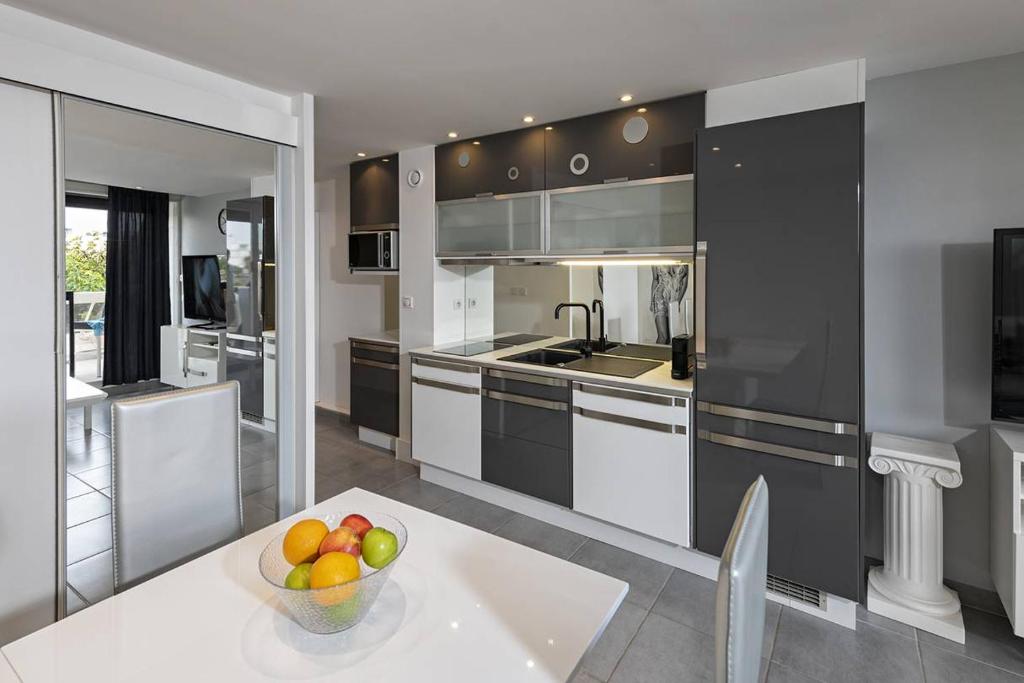 - une cuisine avec un bol de fruits sur une table dans l'établissement Appartement NEW YORK - Héliopolis O15 - Luxe - 2 personnes, au Cap d'Agde