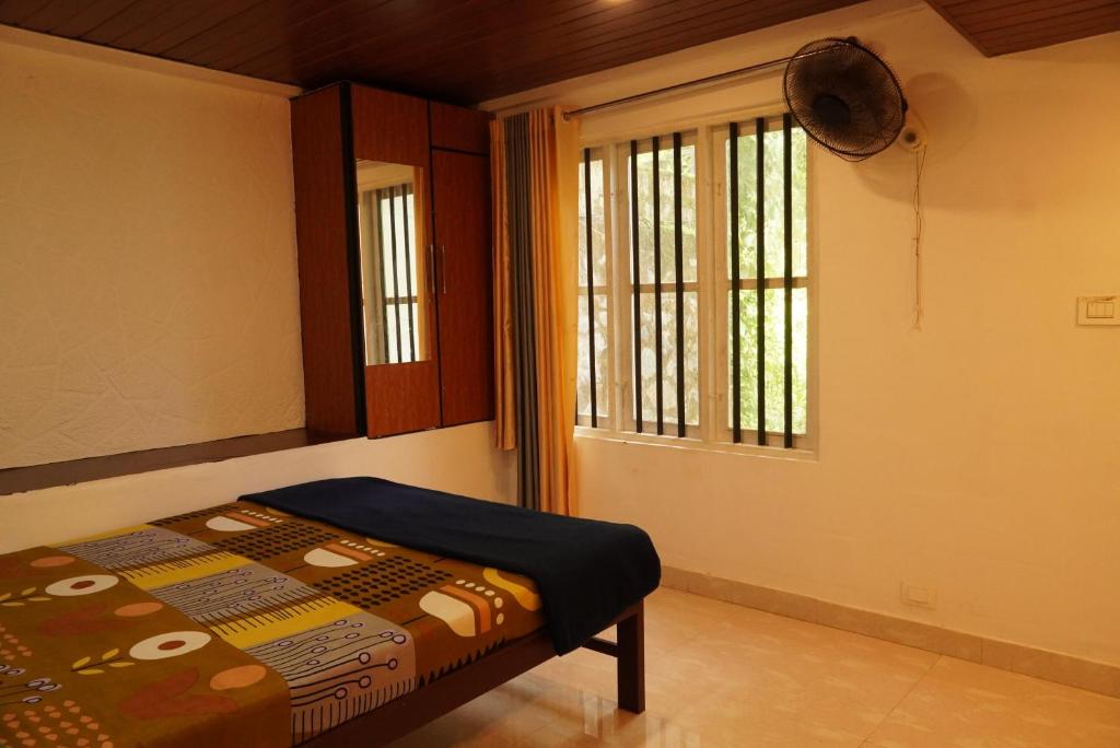 a bedroom with a bed and a window at Wilderstay Resort in Meppādi