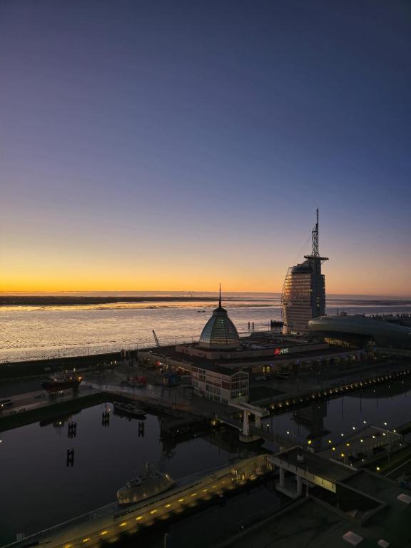 a view of a city at sunset with the ocean at Ferienwohnung Moin in Bremerhaven
