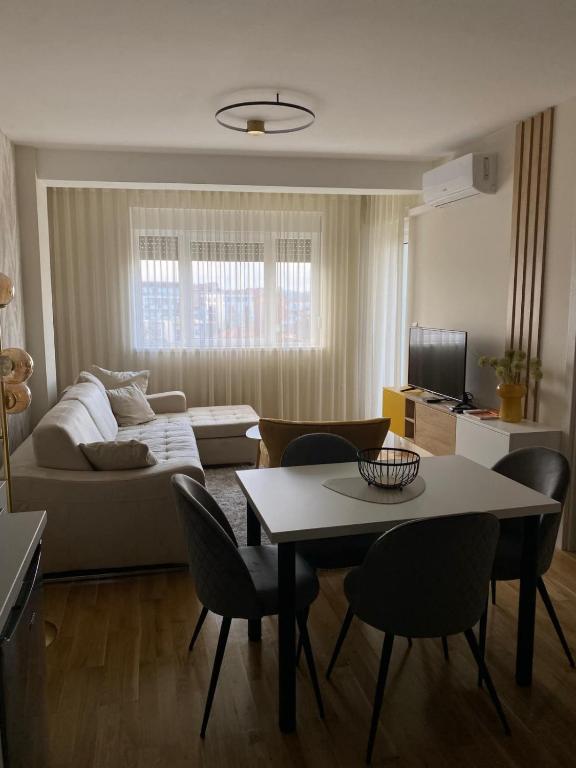 a living room with a couch and a table and chairs at Astera 4 in Vrnjci