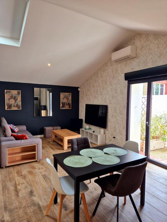 un salon avec une table et des chaises noires dans l'établissement Duplex, Av Charles Trenet, à Narbonne