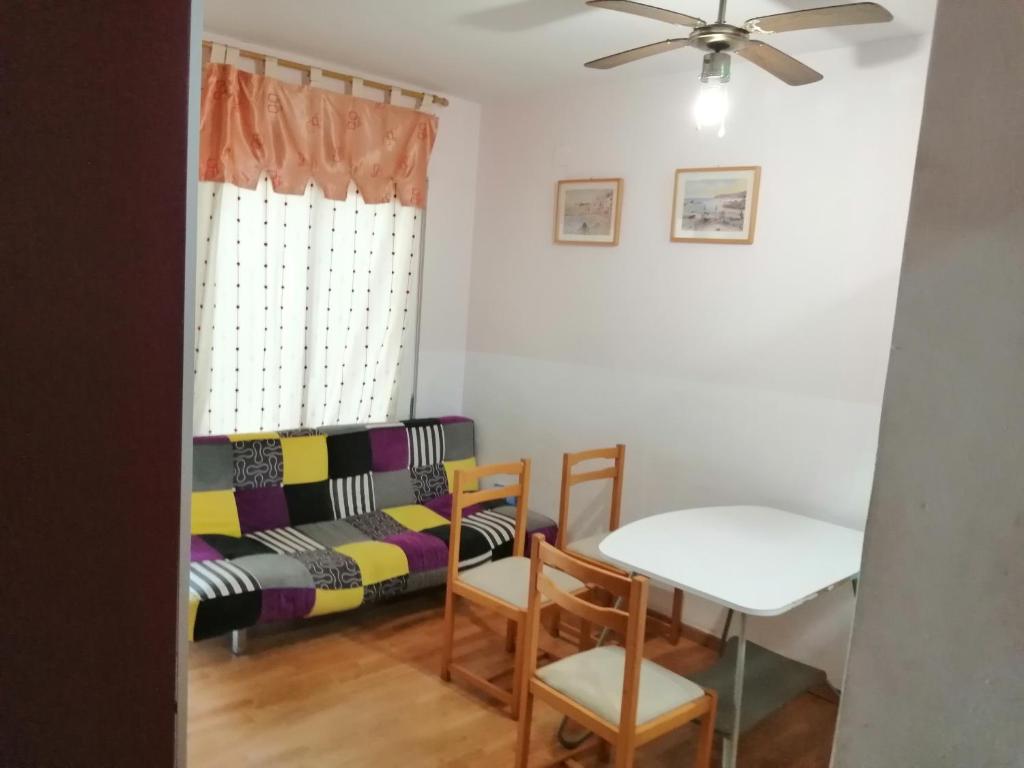 a living room with a table and a couch at Roses in Roses