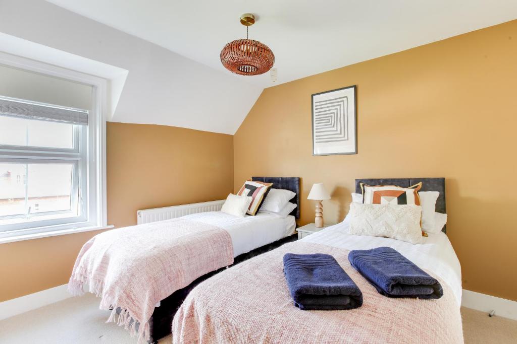 two beds sitting next to each other in a bedroom at Cosy 3 bedroom house with Free parking and WiFi in Colchester