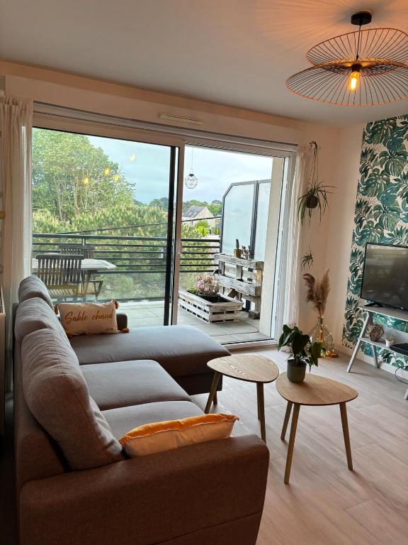 un salon avec un canapé et une grande fenêtre dans l'établissement 2 pièces lumineux, terrasse exposée sud, proche mer, à Saint-Nazaire