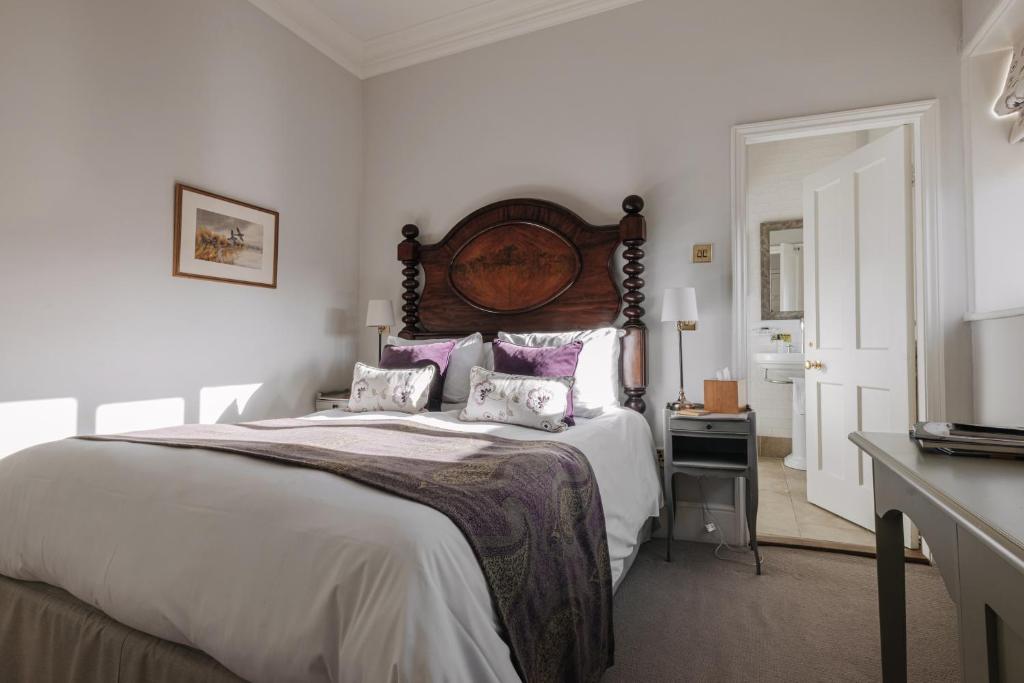 a bedroom with a large bed and a television at Victoria in Holkham