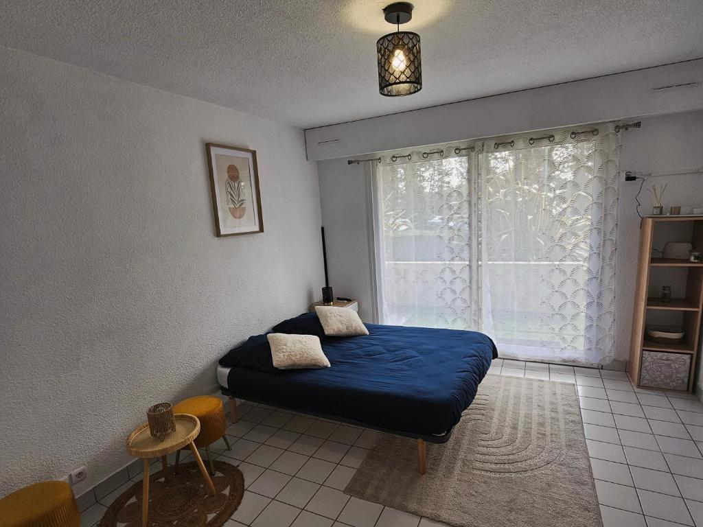 une chambre avec un lit bleu et une fenêtre dans l'établissement Le Relax Studio, à Cherbourg en Cotentin