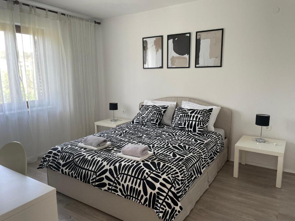 a white bedroom with a bed with black and white sheets at All You Need Holiday in Pula