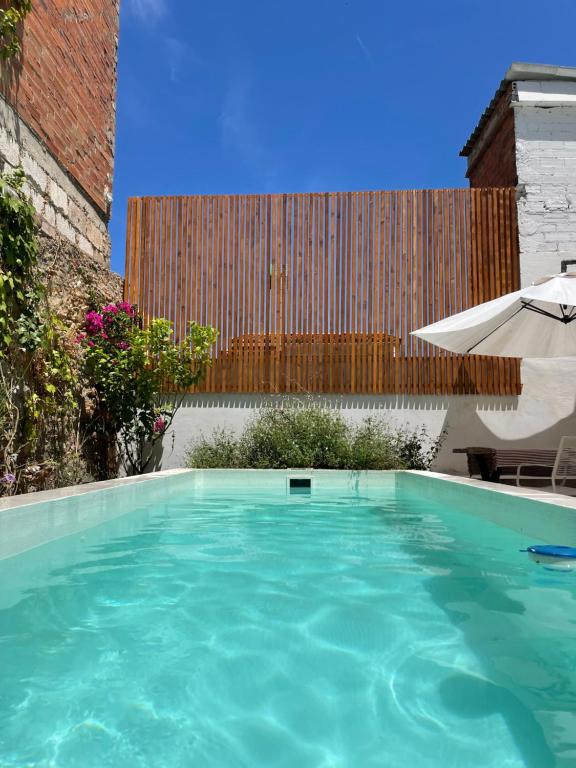 a large swimming pool with an umbrella and an umbrella at Maison de village avec piscine à 10 min de la plage Costa Brava in Sant Feliu de Guixols