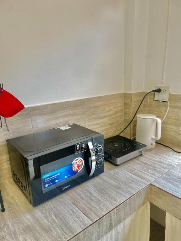 a microwave sitting on a counter next to a stove at Unity coliving in Thong Sala