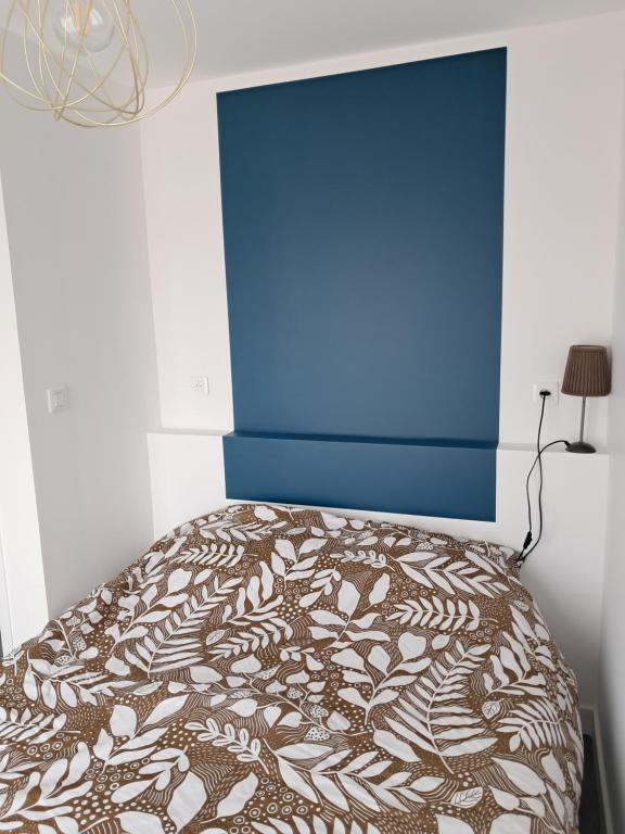 une chambre avec un lit avec un mur bleu et un mur bleu dans l'établissement Les deux tilleuls, à Les Rosiers