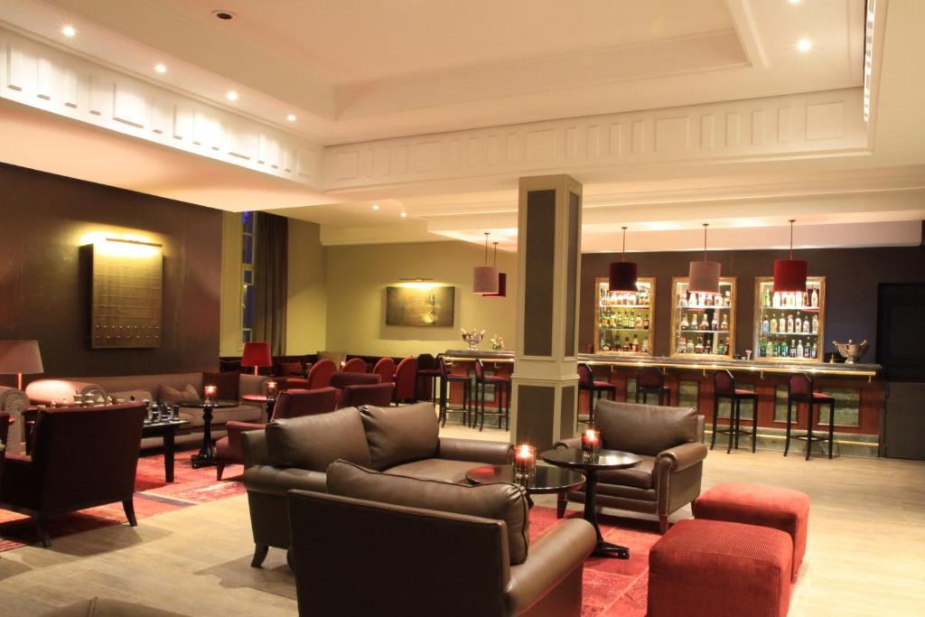a hotel lobby with couches and a bar at Berbère Palace in Ouarzazate
