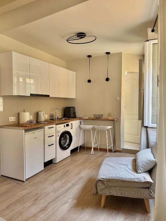 a kitchen with white cabinets and a table at Lumière Carmela in Corfu