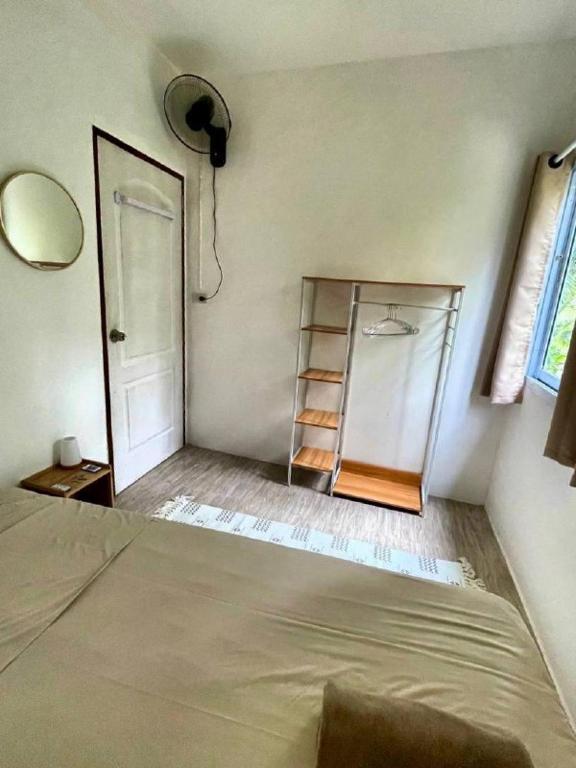 a room with a bed and a mirror and a shelf at Unity coliving in Thong Sala