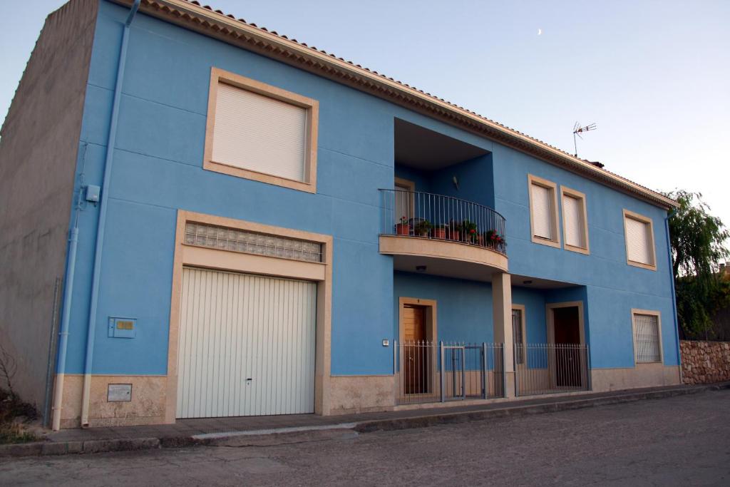 a blue building with two garage doors and a balcony at Casa Laureana in Ruidera