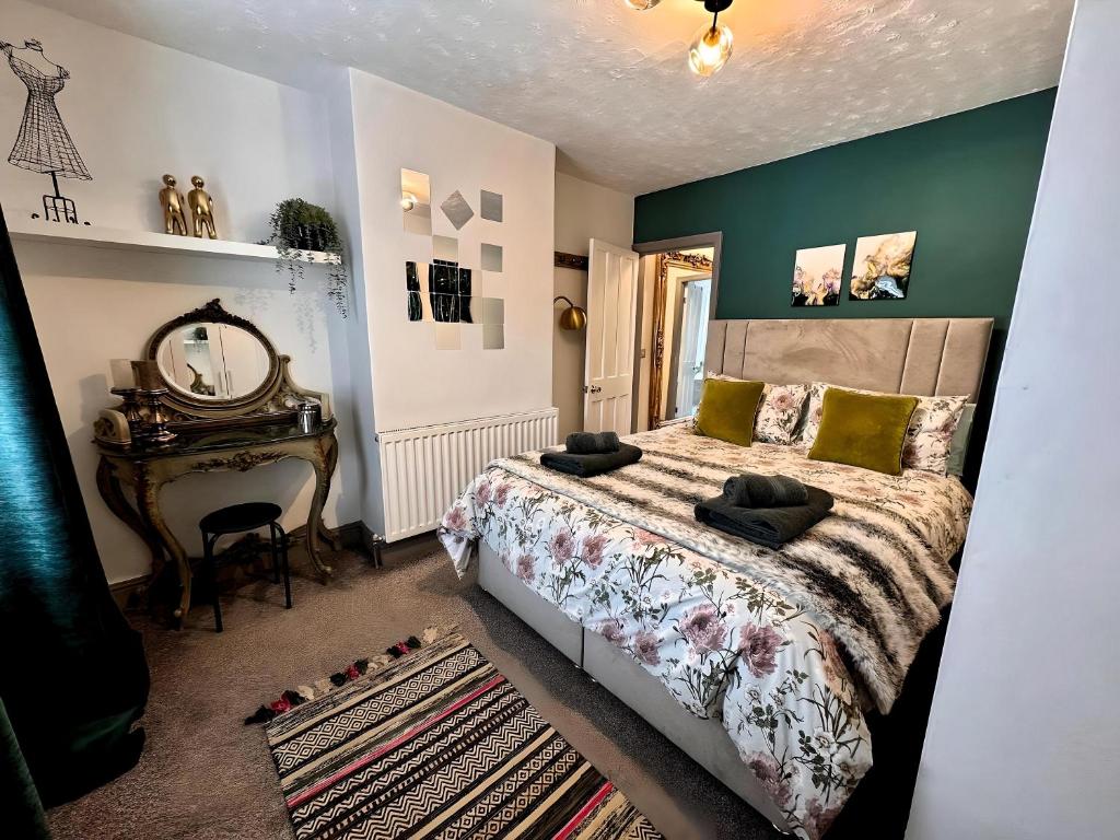 ein Schlafzimmer mit einem Bett, einem Spiegel und einem Tisch in der Unterkunft Stylish Uphill Townhouse in Lincoln