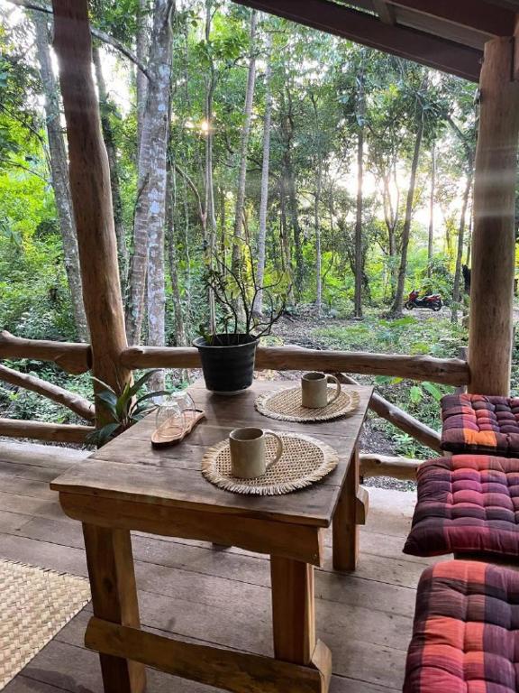 a wooden table with two coffee cups on a porch at Unity coliving in Thong Sala