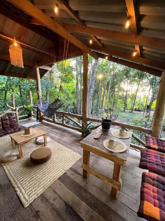 a porch of a house with tables and a swing at Unity coliving in Thong Sala