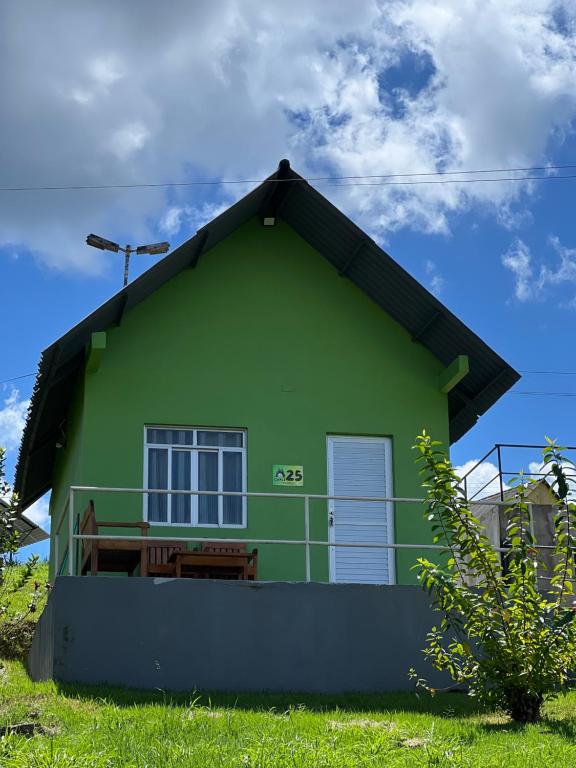 a green house with a window on the side of it at Chalé em Parque Aquático - Presidente Figueiredo in Presidente Figueiredo