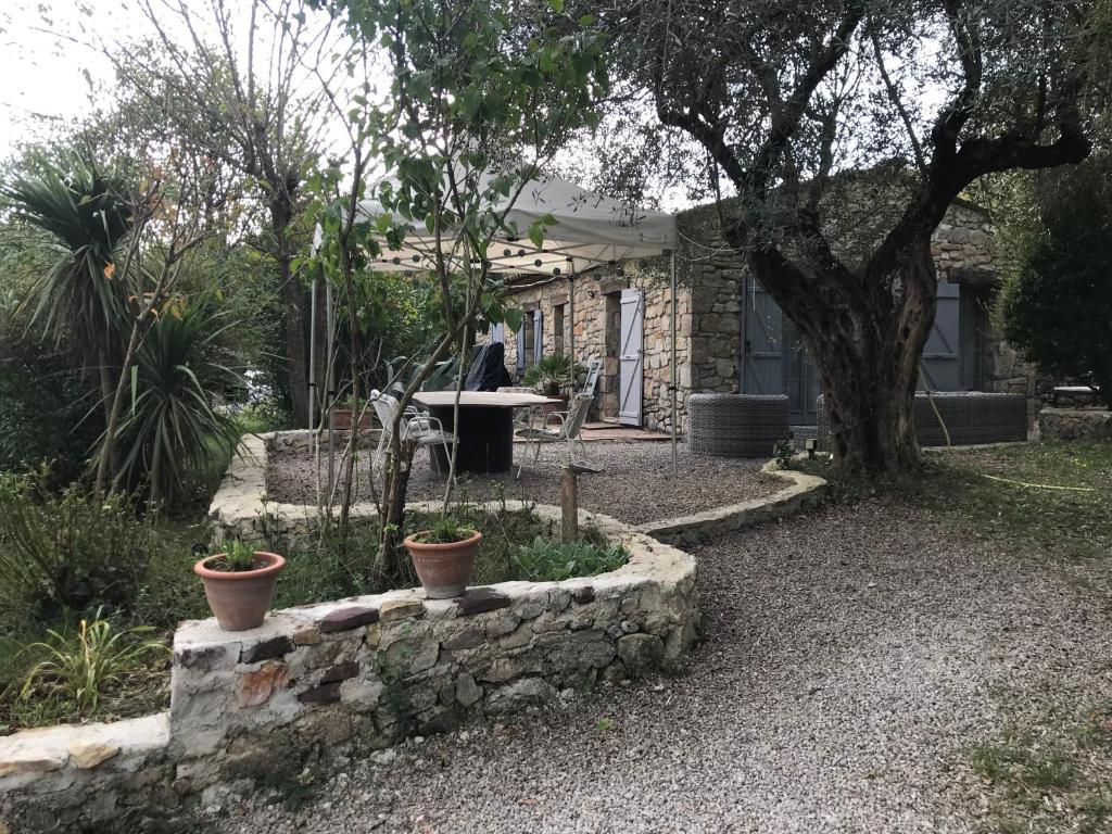 une maison avec une table et quelques plantes dans une cour dans l'établissement Charmante maison, à Fayence