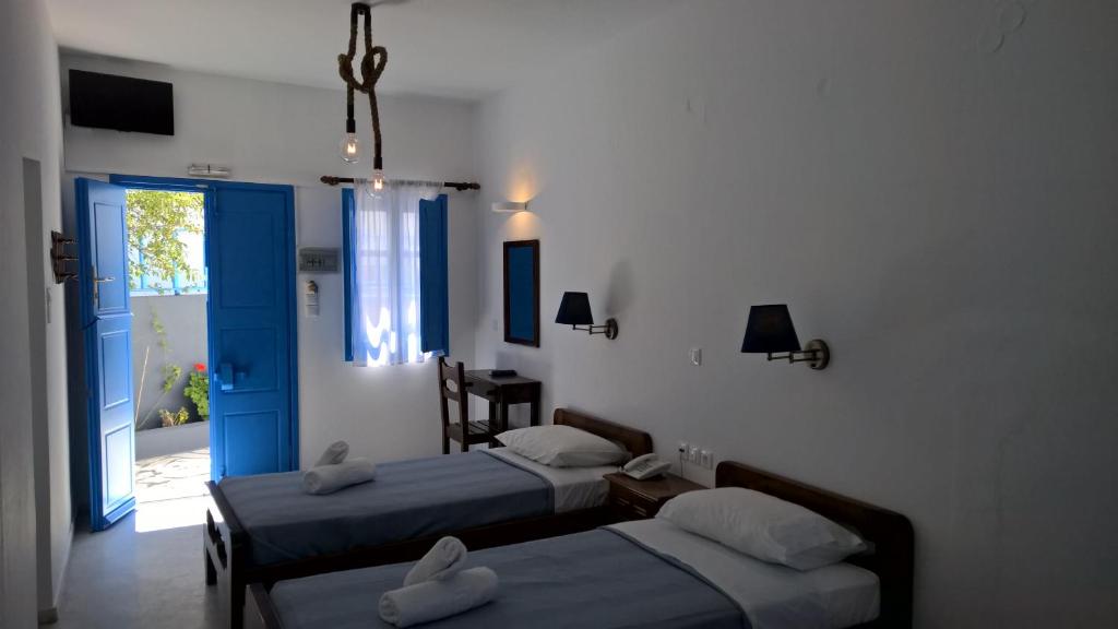 sypialnia z 2 łóżkami, oknem i drzwiami w obiekcie Laokasti Villas w mieście Oia