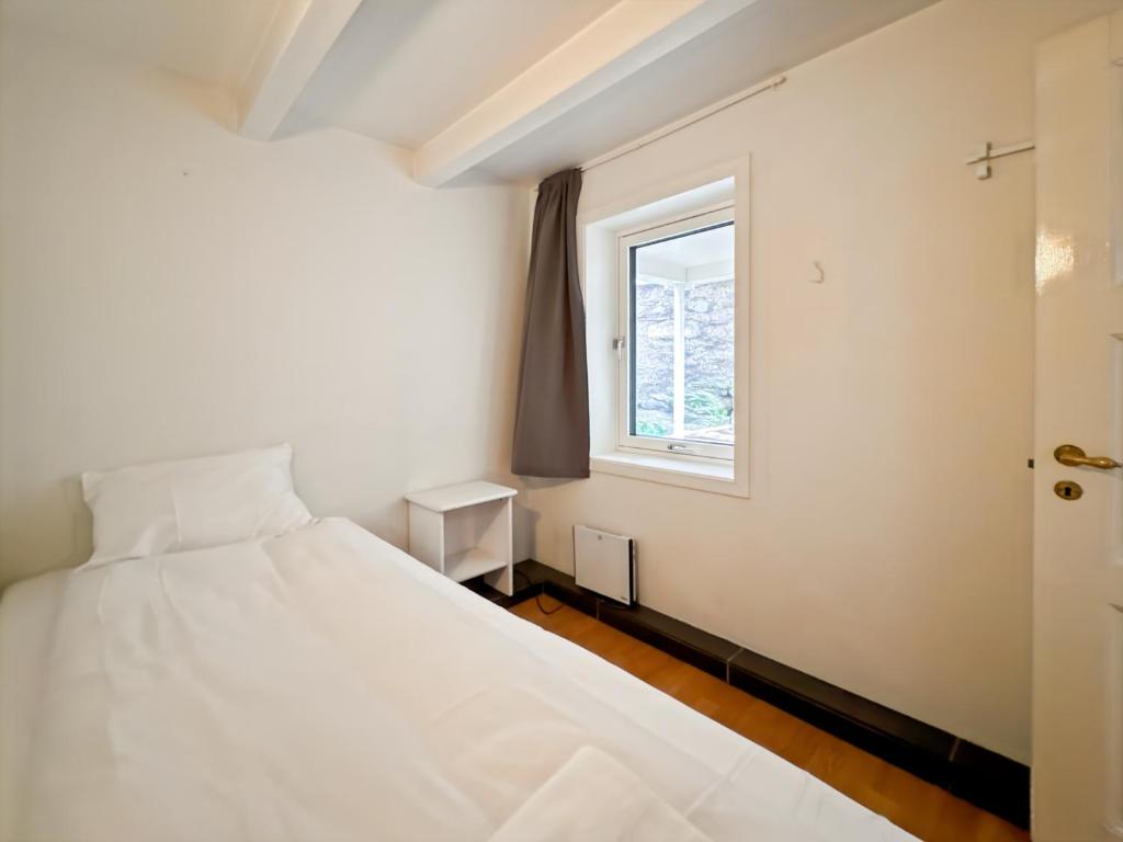 a bedroom with a white bed and a window at The History Hub by Stavanger BnB 28 in Stavanger