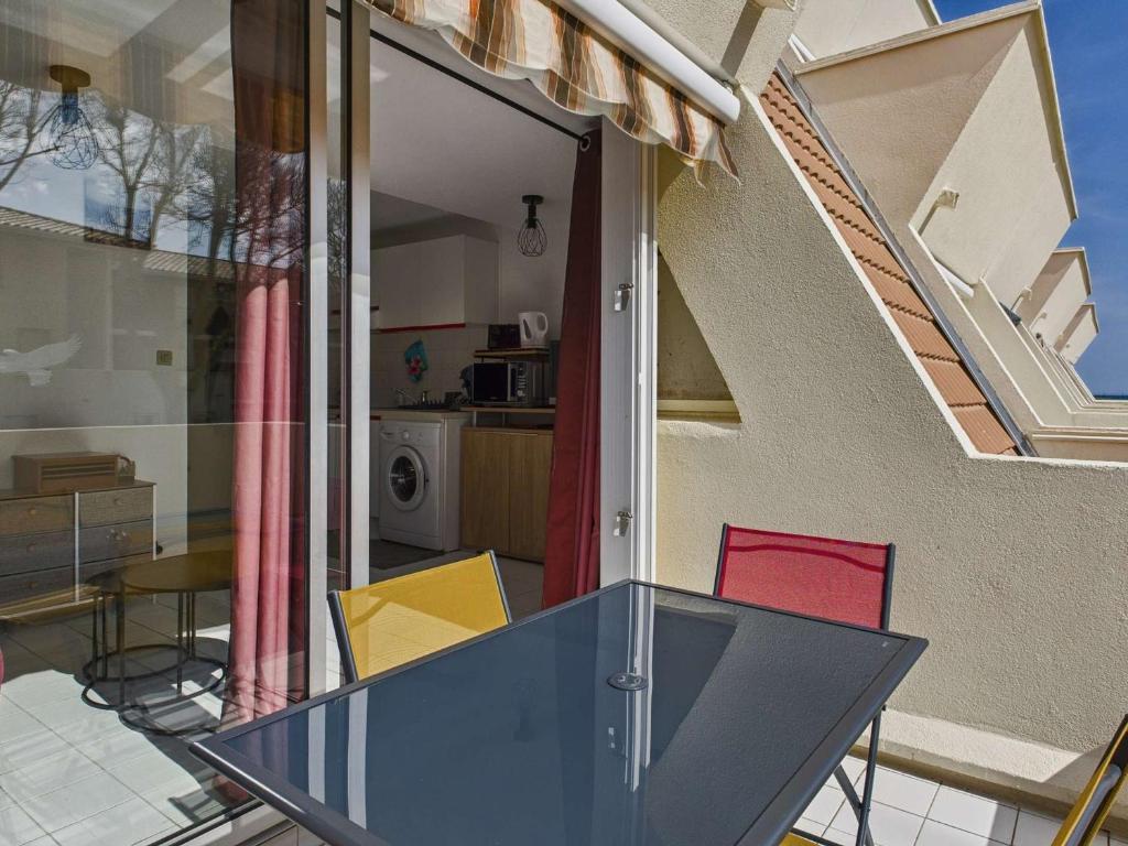 une table en verre devant une maison dans l'établissement Appartement cosy 2 pièces, 4 pers., à 2 pas de la plage, parking privé, terrasse avec salon de jardin - FR-1-326-815, à Marseillan